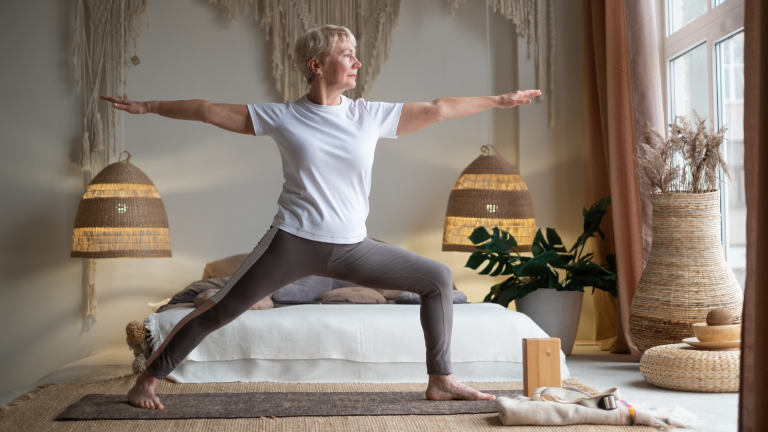 1_senior_woman_practicing_yoga_standing_in_warrior_ll_pose_or_virabhadrasana_ii_pose_a_bone-strengthening_pose_to_help_prevent_osteoporosis